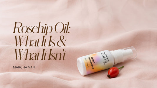 Witchy Lashes Retinyl Renewal Oil bottle resting beside a rosehip berry on pink linen