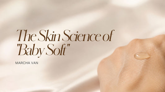 Drop of serum resting on the back of a smooth hand against soft linen — the science of baby soft skin