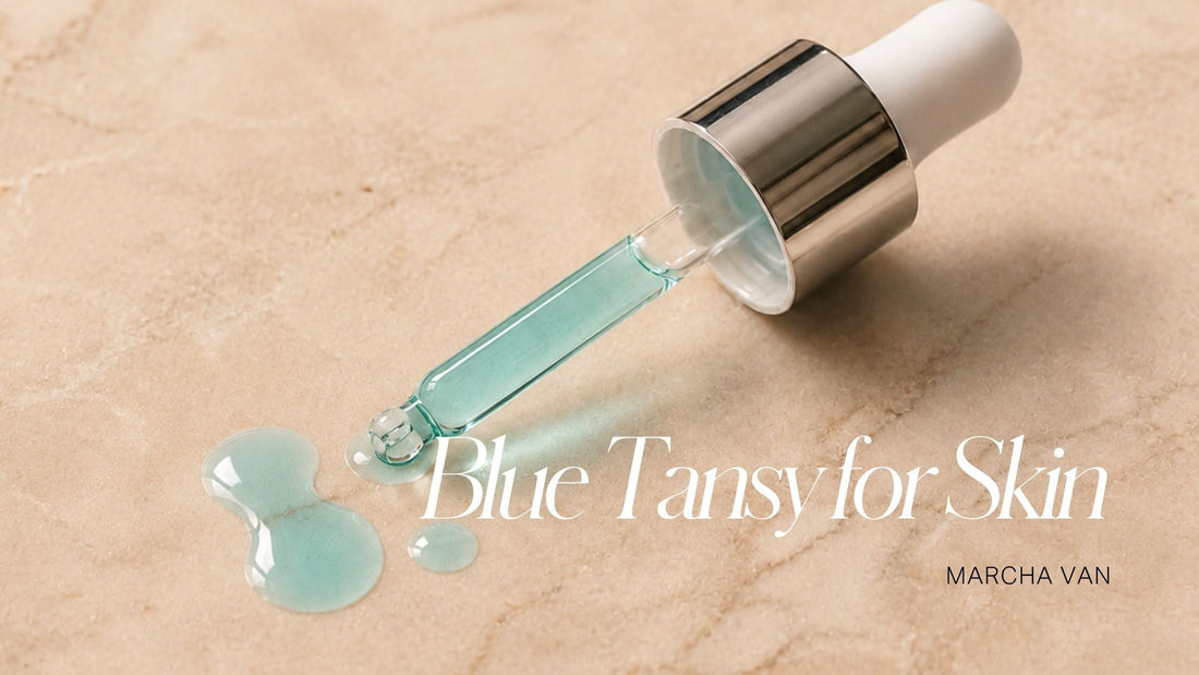 Blue tansy facial oil dropper with teal-coloured serum pooled on a warm sandy stone surface