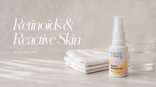 Witchy Lashes Skin Retinyl Renewal Oil bottle beside a folded white cloth and a glass of water on a pale stone surface