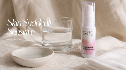 Witchy Lashes Skin Hyaluronic Acid Serum bottle next to a glass of water and a ceramic dish on linen fabric