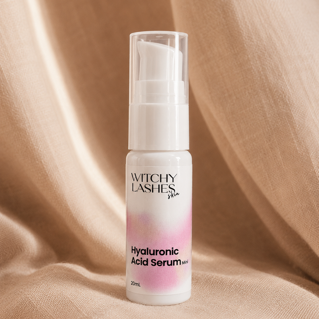 Witchy Lashes Hyaluronic Acid Serum bottle on a beige fabric background